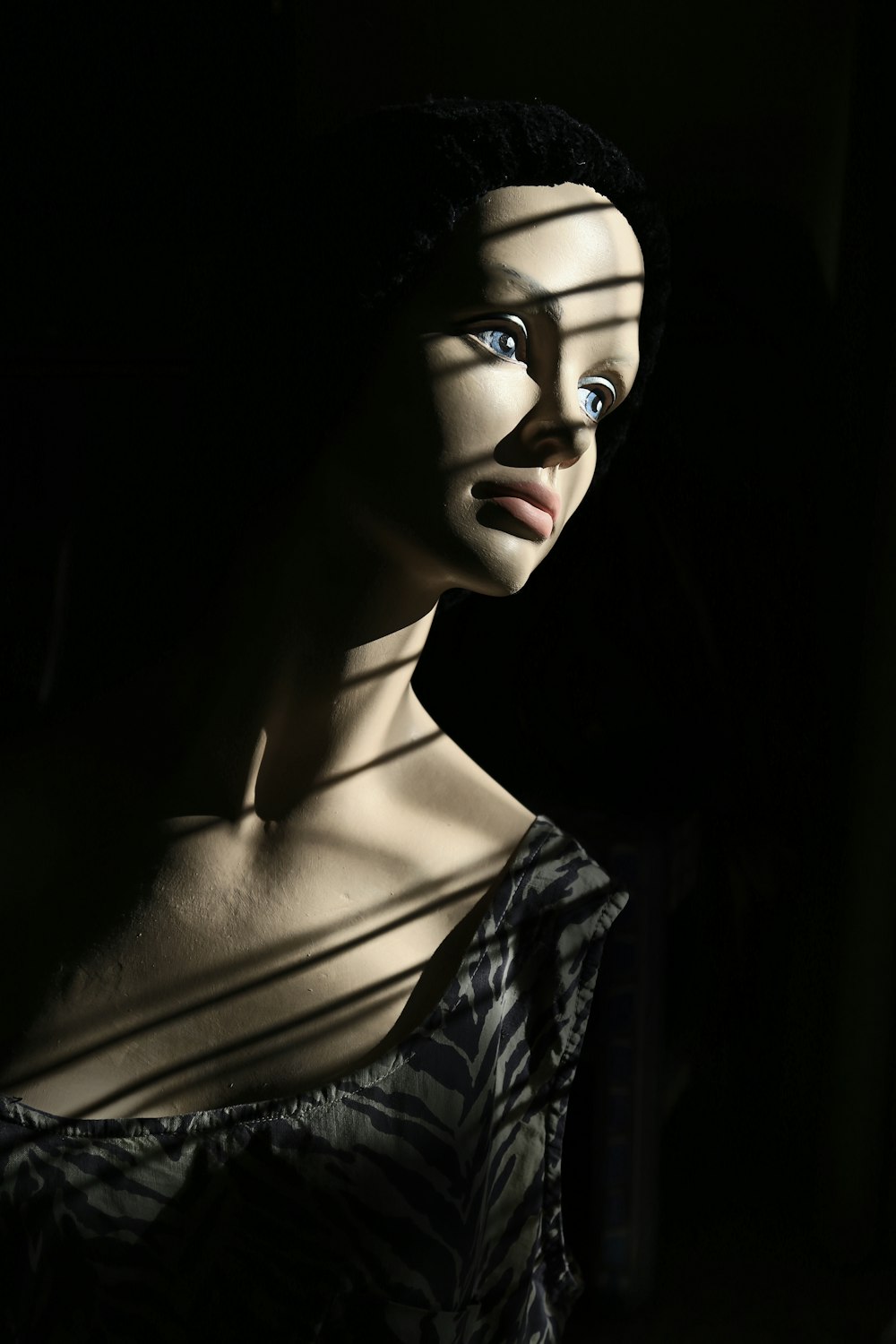 a mannequin with blue eyes in a dark room