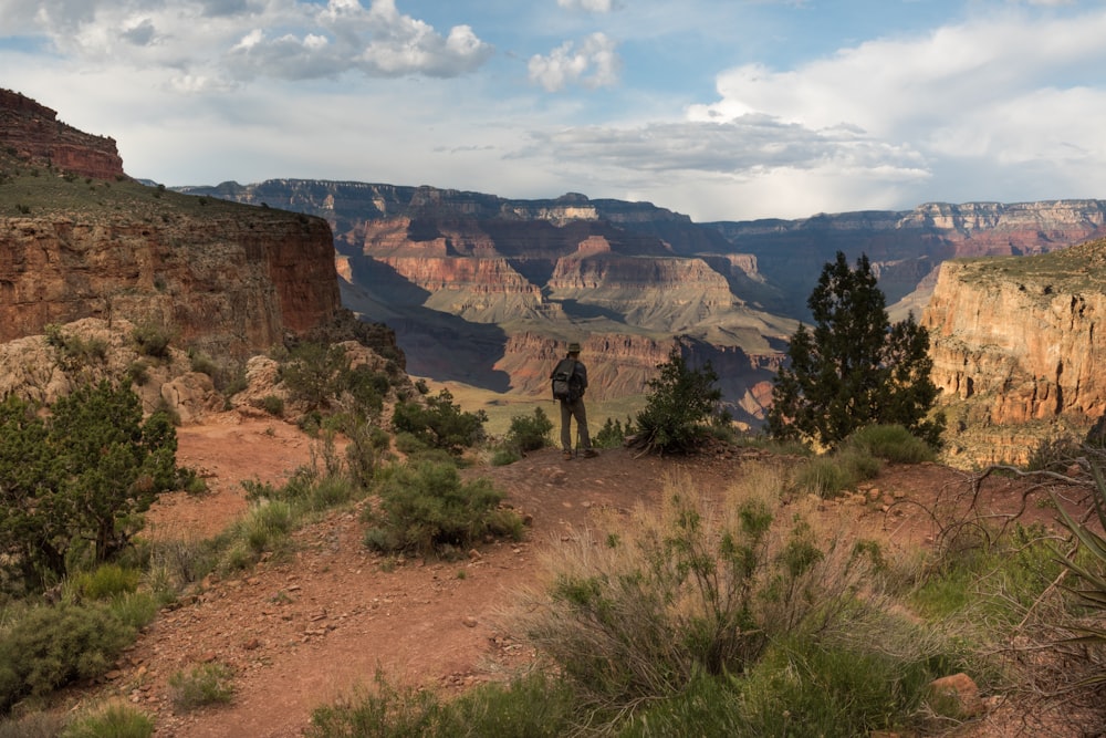 man standing on hill mountain during daytime