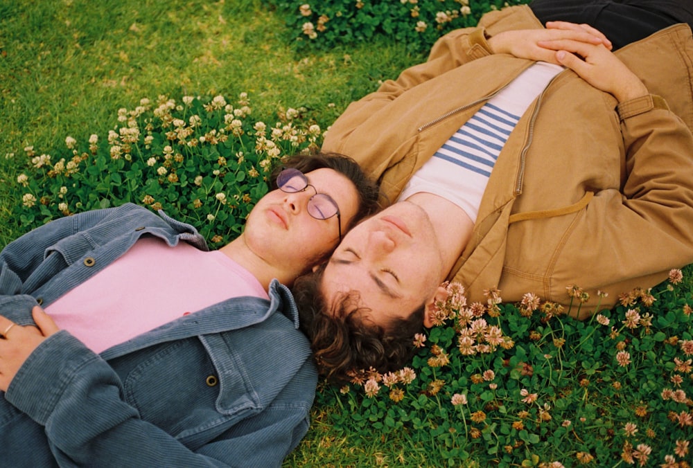 two man lying on grass with flowers