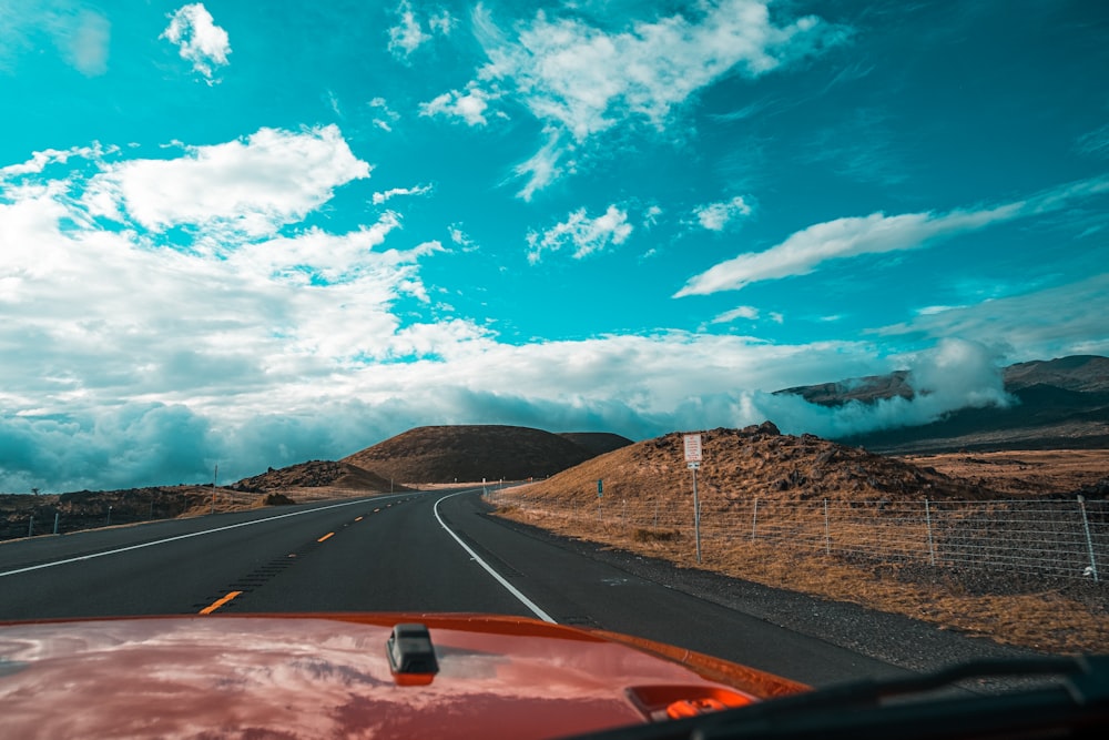 red vehicle on road during daytime