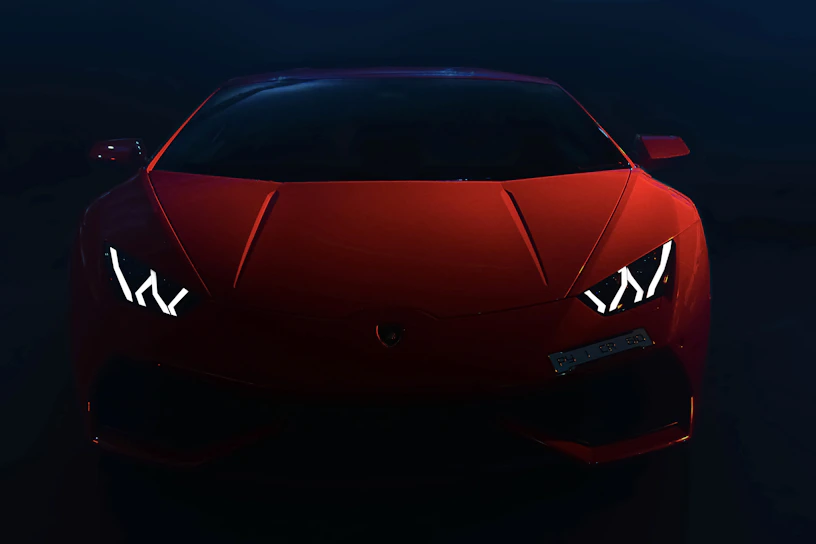 Sleek red sports car front view under dramatic lighting