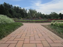 Freshly completed brick pathway winding through a colorful garden.