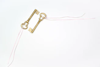 Close-up of golden keys on a light blue background, symbolizing trust and quality service.