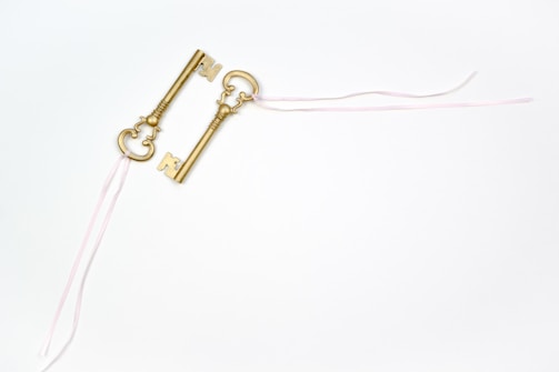 An open golden key resting on a rich purple cloth.