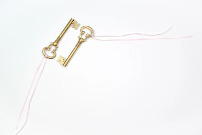 Close-up of golden keys on a light blue background, symbolizing trust and quality service.