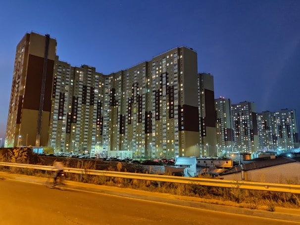 Modern housing development near a busy city road at dusk.