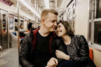 woman hugging man while sitting inside train