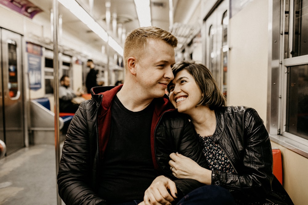 電車の中に座っている間に男を抱きしめる女性