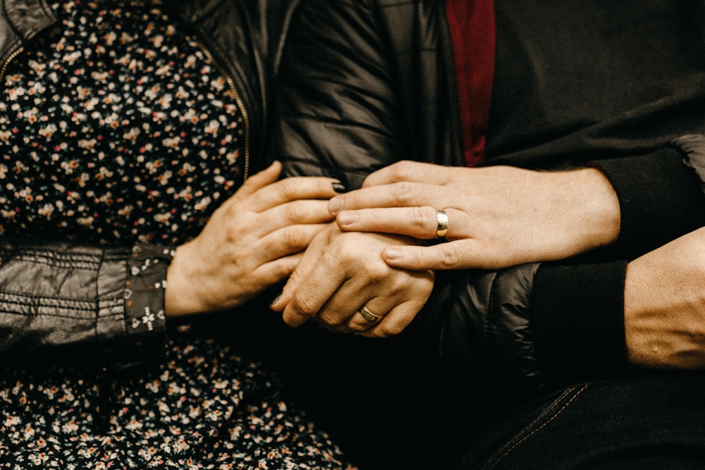 a close up of two people holding hands