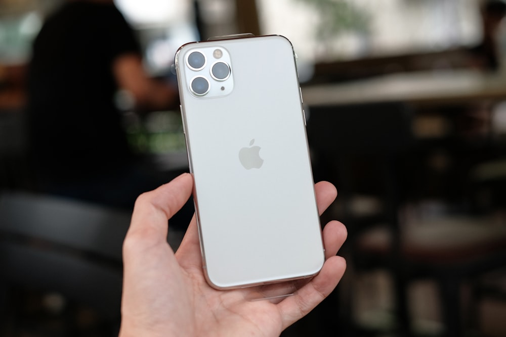 persona sosteniendo un iPhone 11 blanco