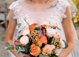 selective focus photography of bride holding flower bouquet