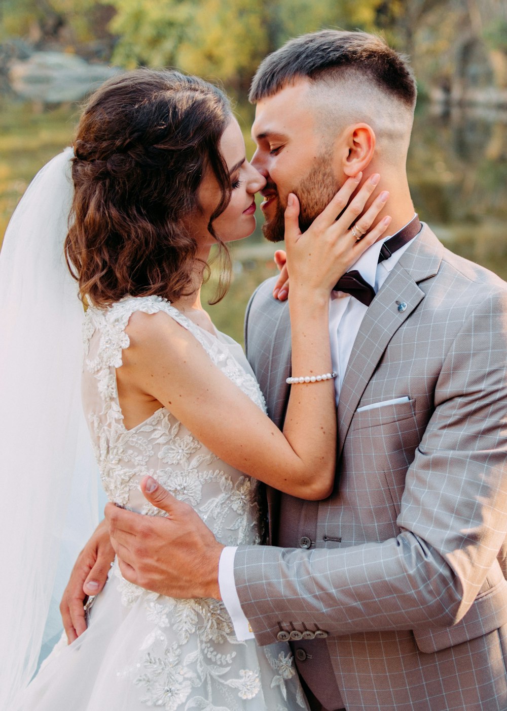 woman and man about to kiss by body of water