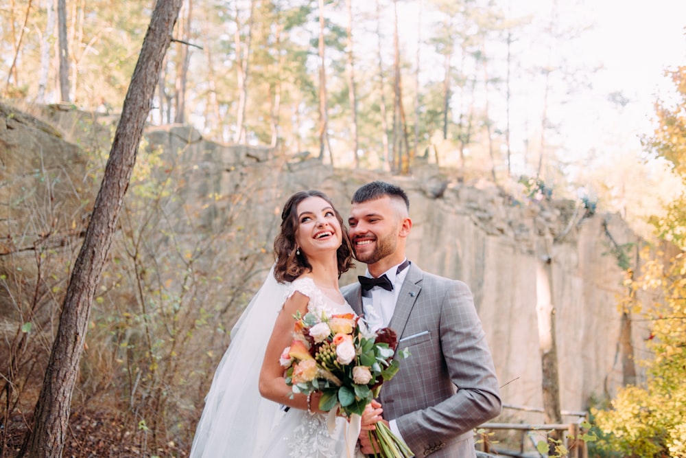 man and woman both laughing by tree during daytime