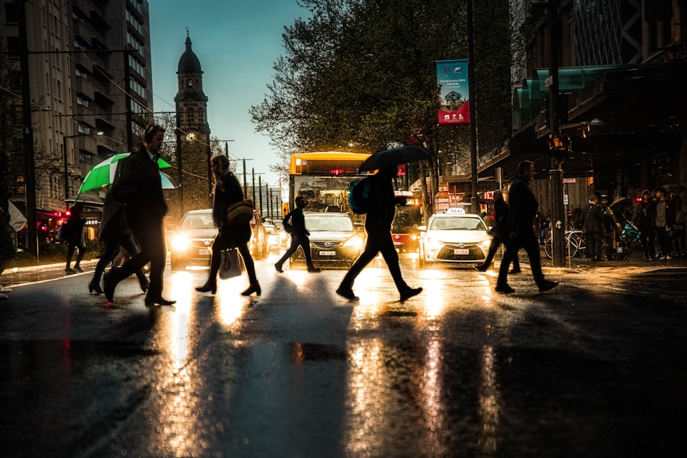 Personas que caminan por el carril peatonal durante un día lluvioso