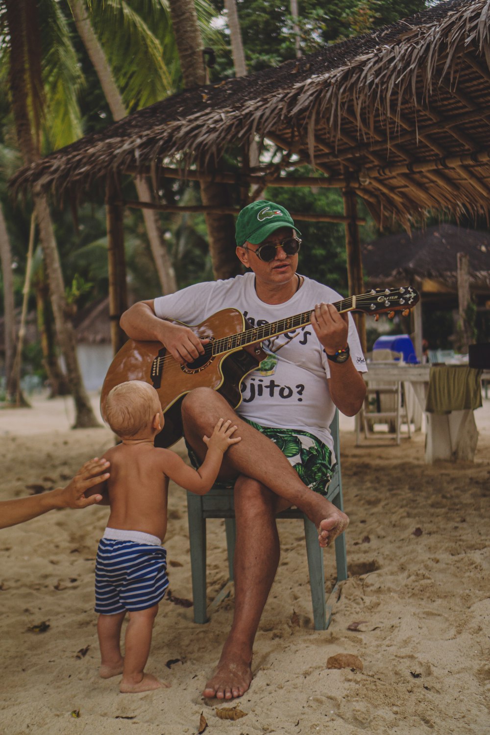 man sitting on chair while playing guitar