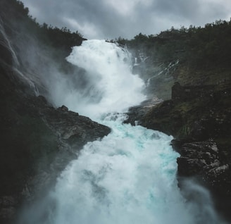 waterfalls under grey sky