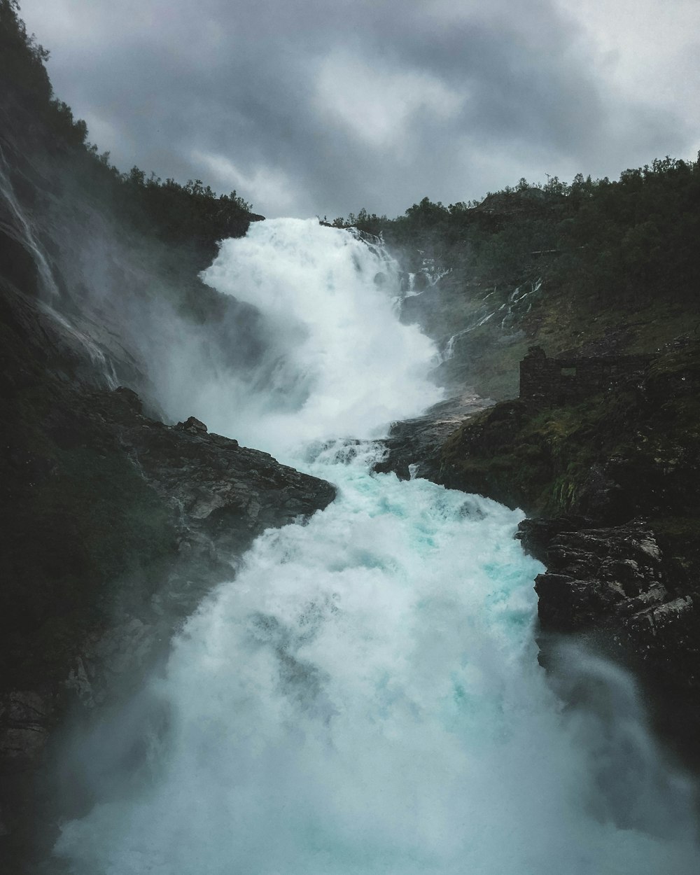 waterfalls under grey sky