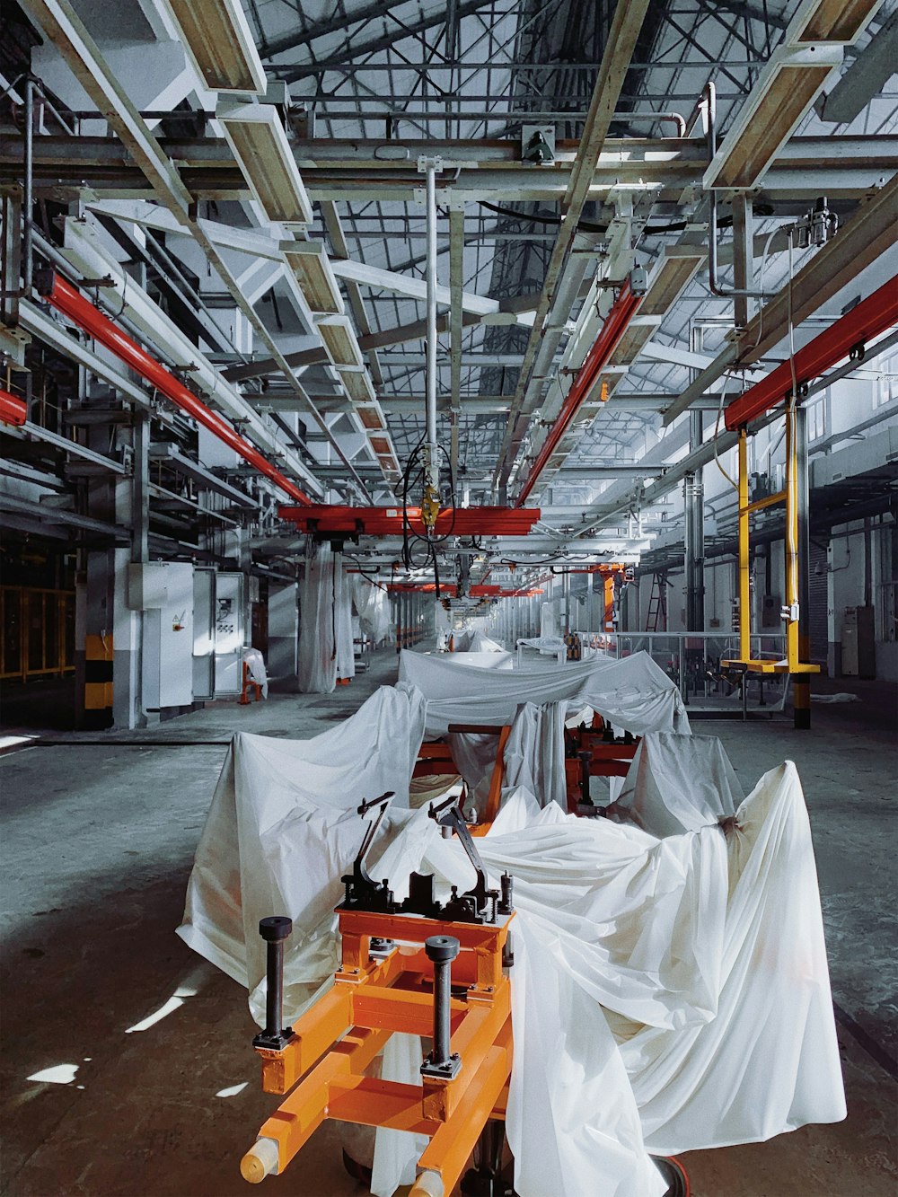 orange industrial machine covered with white textiles