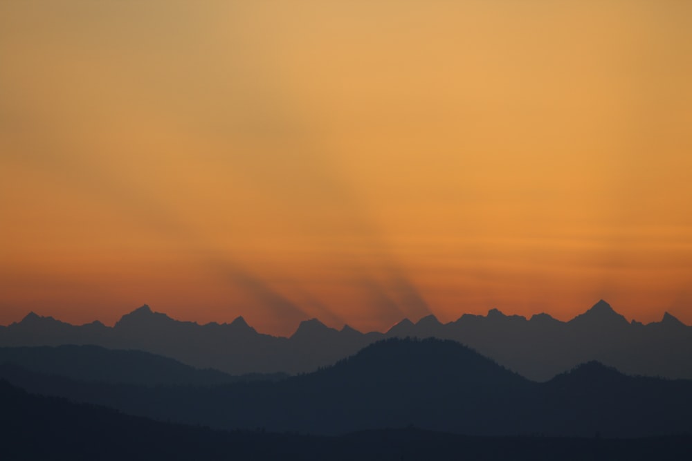 silhouette of mountain under orange sky