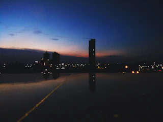 A cinematic cityscape at dusk with glowing lights and reflective surfaces