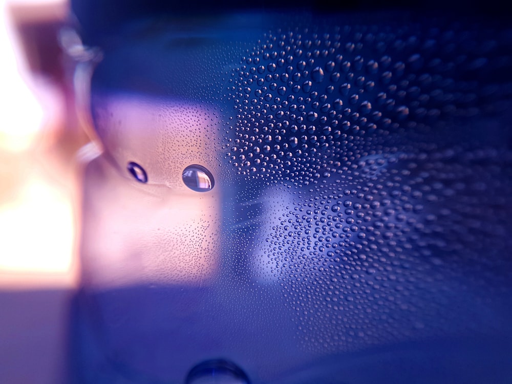 a close up of a blue bottle with water droplets