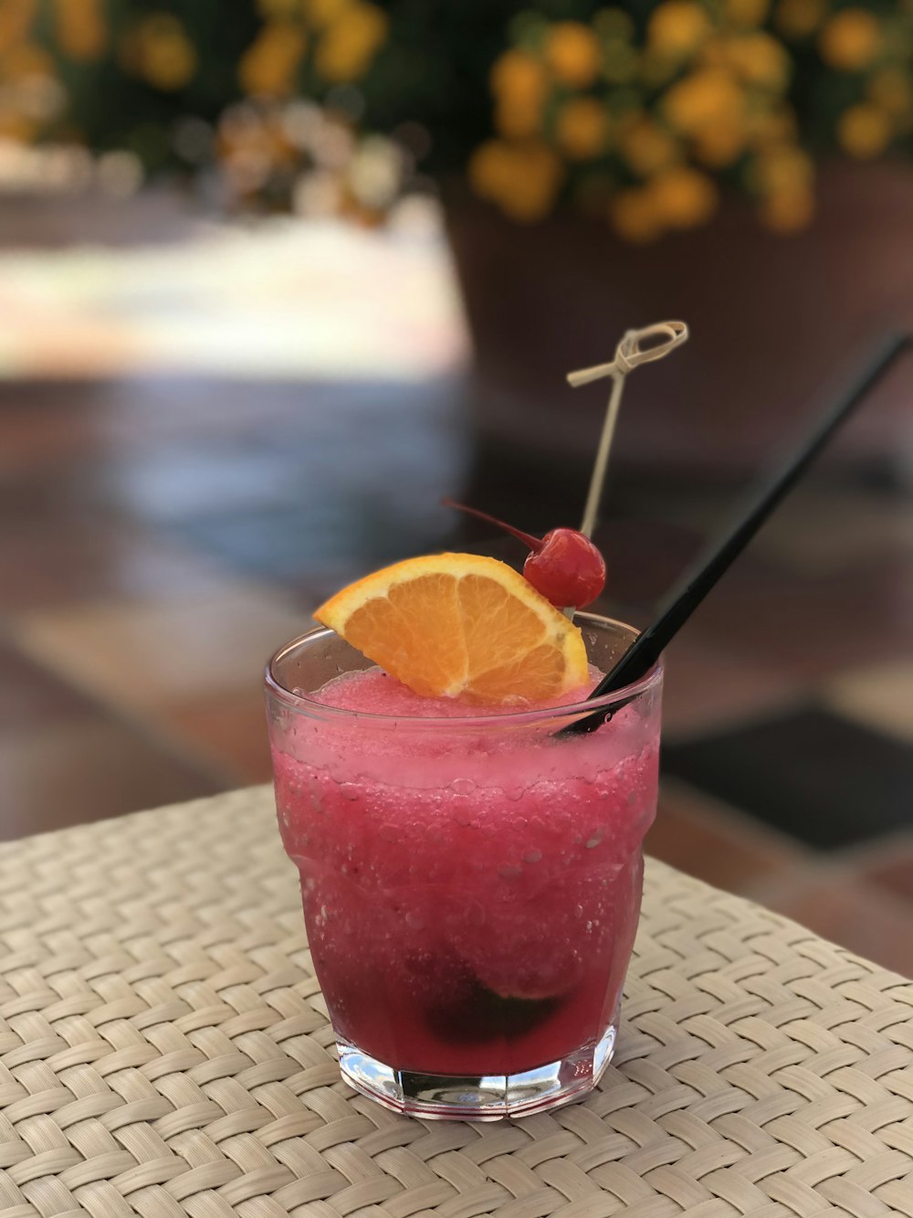 clear drinking glass with pink liquid and sliced orange fruit