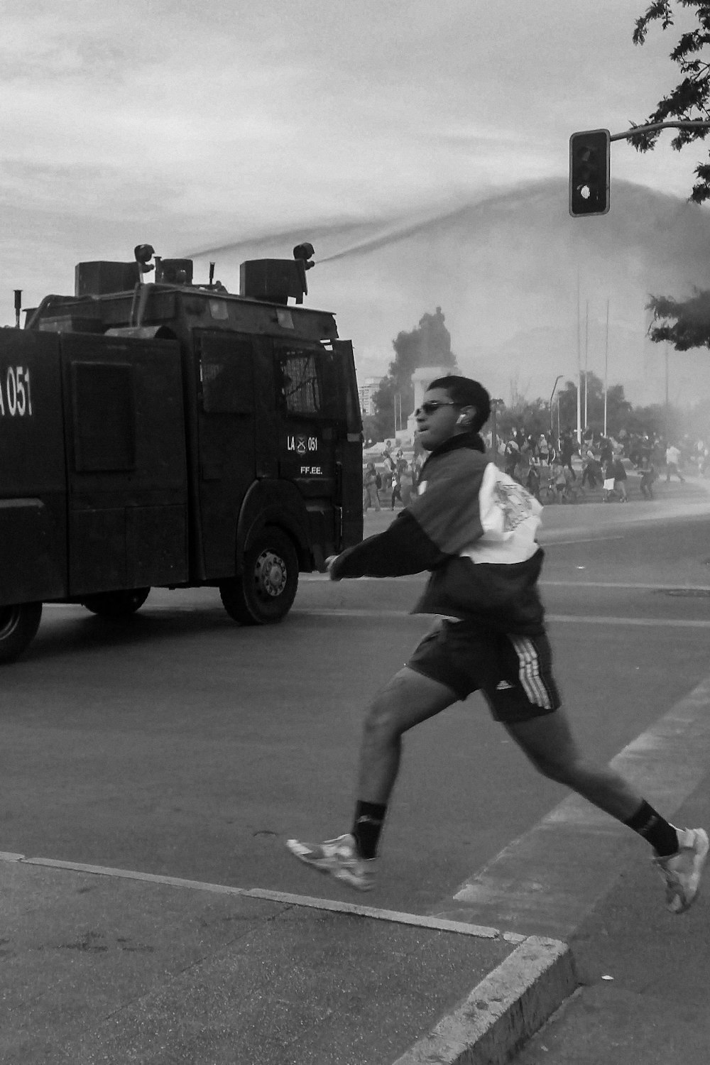 greyscale photo of man crossing road