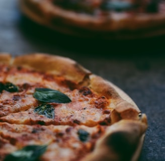 selective focus photography of two pizzas