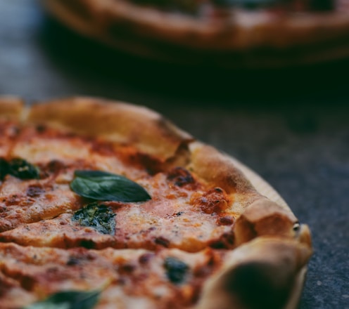 selective focus photography of two pizzas