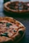selective focus photography of two pizzas