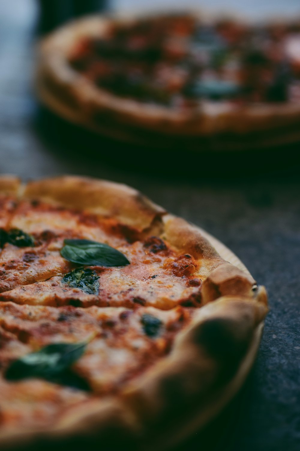 selective focus photography of two pizzas