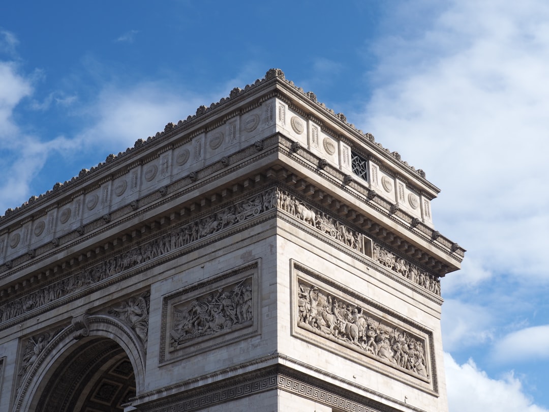 arch de triumph under clear blue sky and white clouds