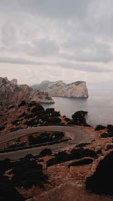 A winding coastal road overlooking turquoise sea and rugged cliffs