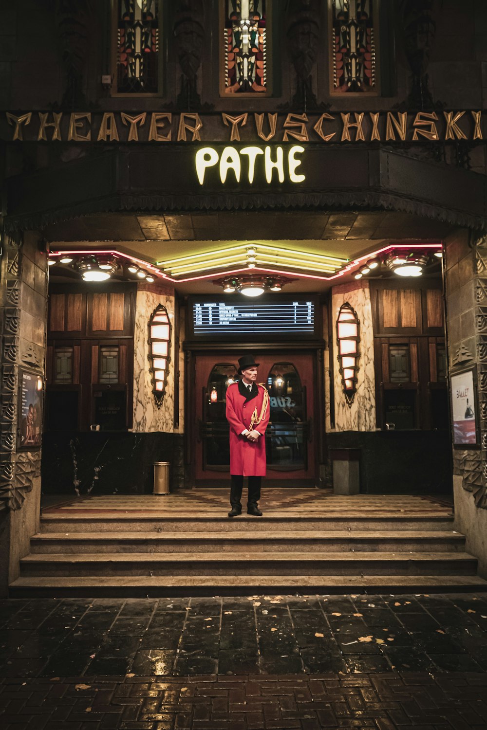 man in red cardigan standing in front of Pathe building