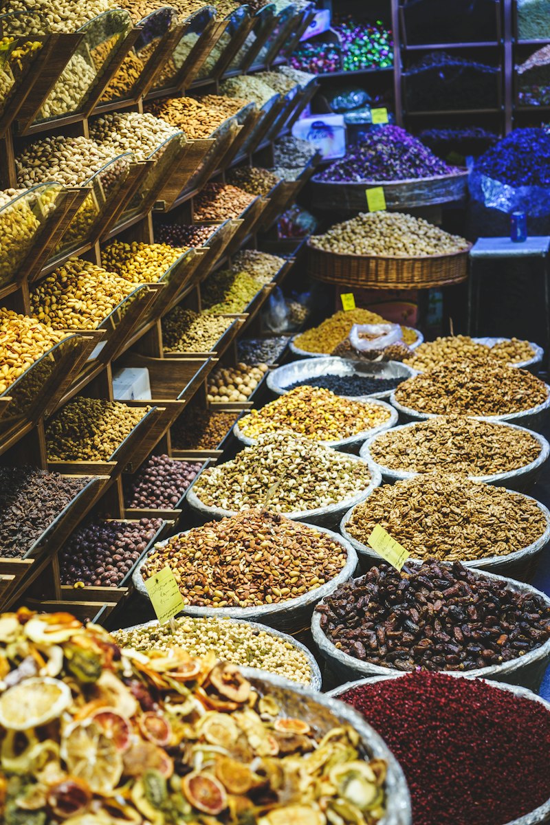 Assorted dried herbs and seeds in small apothecary containers.