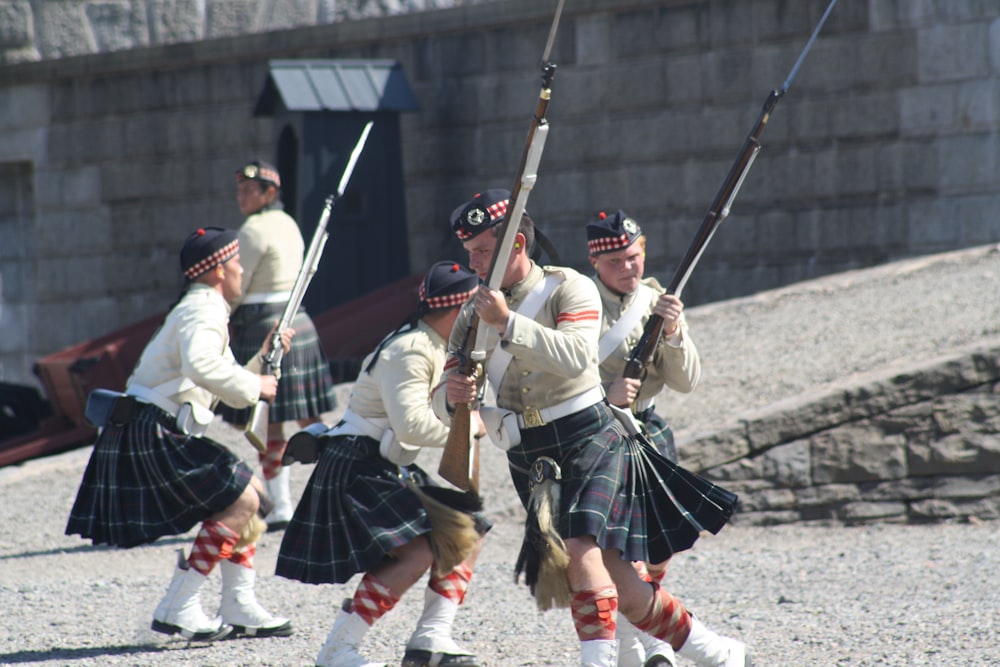 a group of men in kilts playing a game of bagpipes