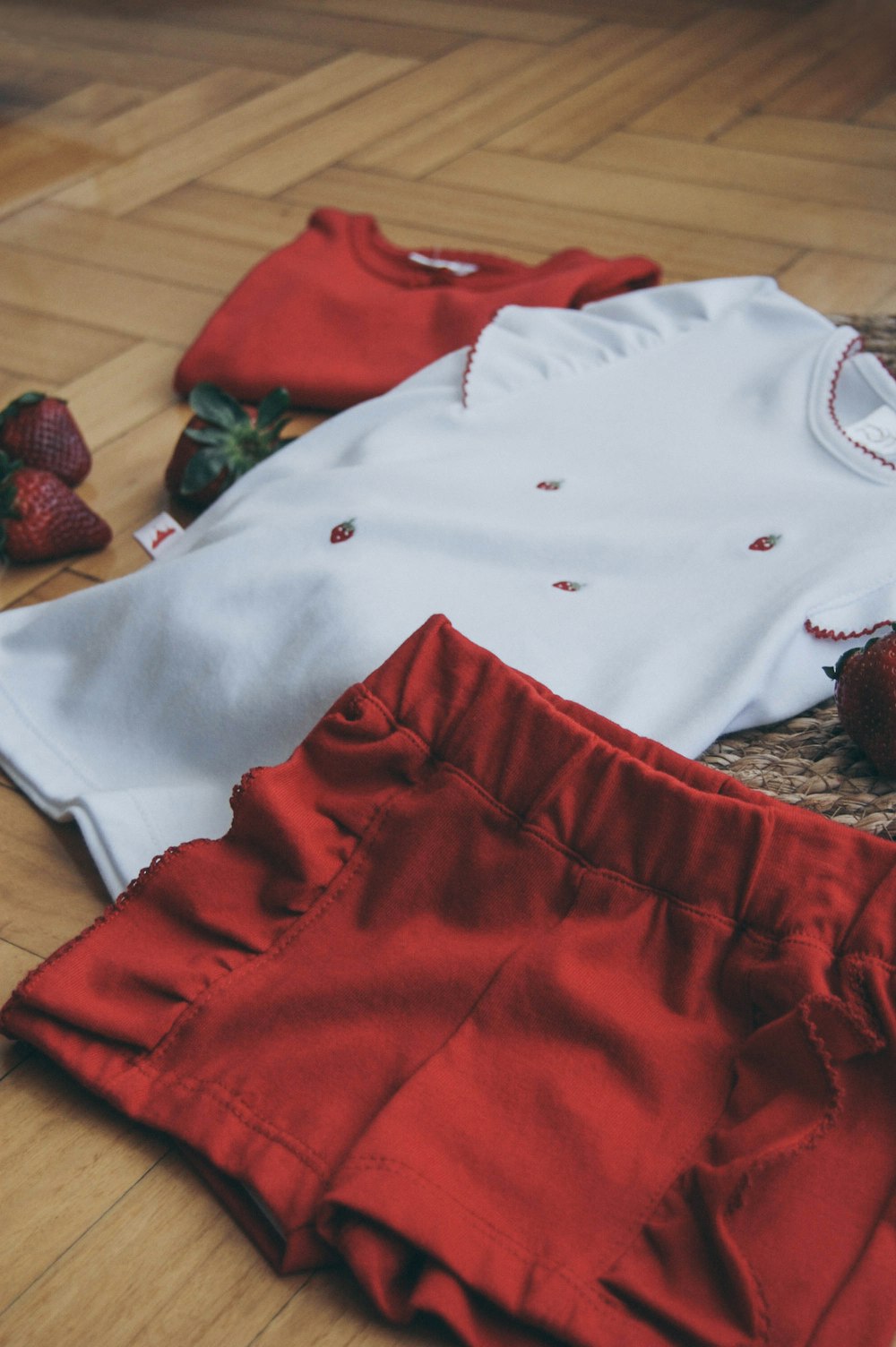 red shorts and white shirt on brown surface