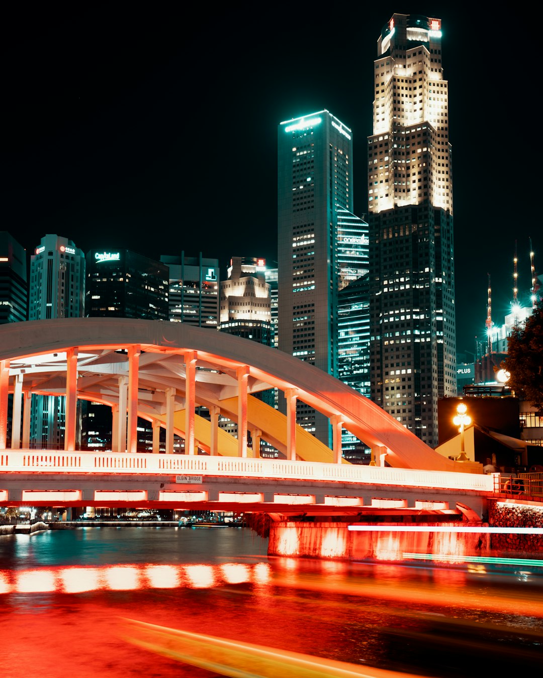 photography of lighted arc bridge near buildings