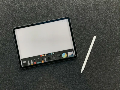 A tablet displaying a creative design app with tools and vibrant artwork on screen.