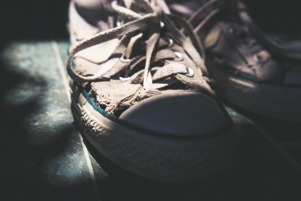 pair of white sneakers with tied shoelace