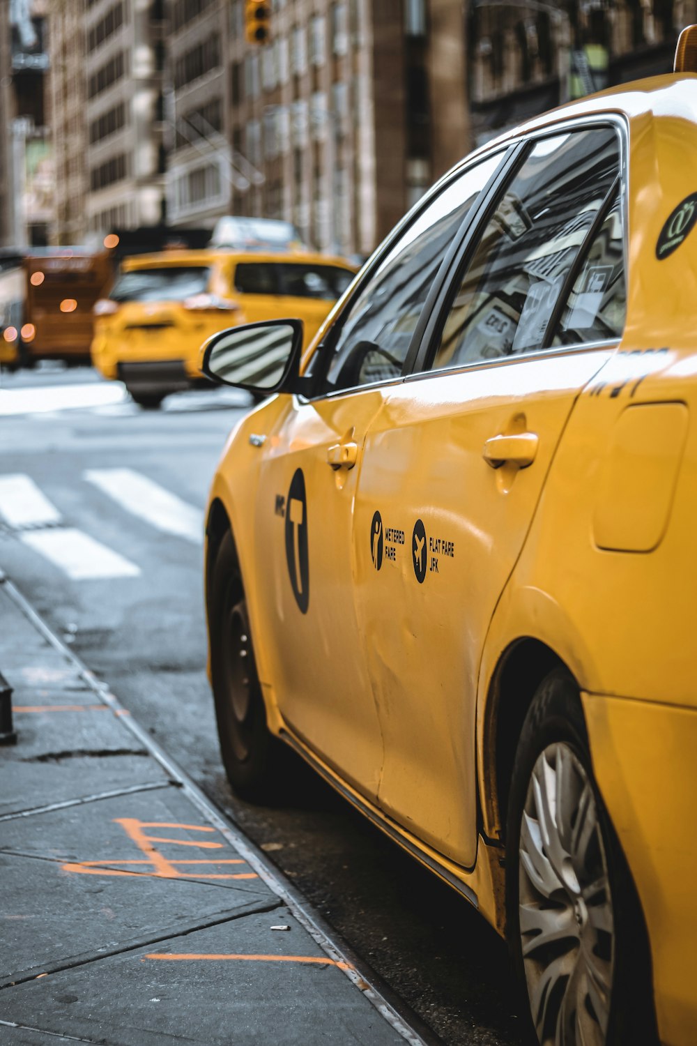 Táxi amarelo estacionado ao lado do meio-fio