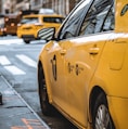 yellow taxi parked beside curb