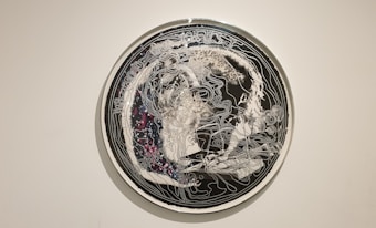 An intricate circular artwork featuring abstract line patterns overlaid on a dark background with hints of galaxy-like speckles. The design appears to be a fusion of organic and cosmic elements, creating a sense of depth and complexity.