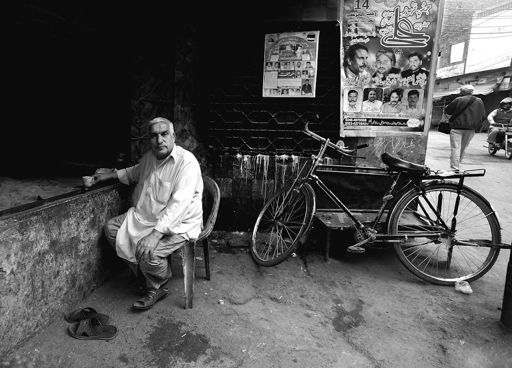 a man sitting on a ledge next to a bike