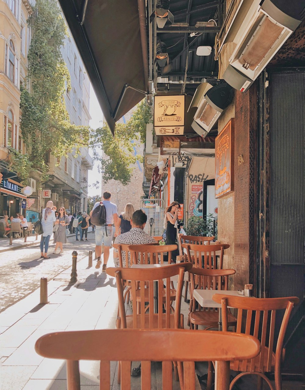 people walking near brown wooden tables beside building