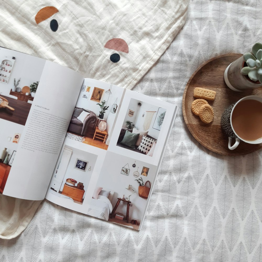 a book opened on a bed next to a cup of coffee