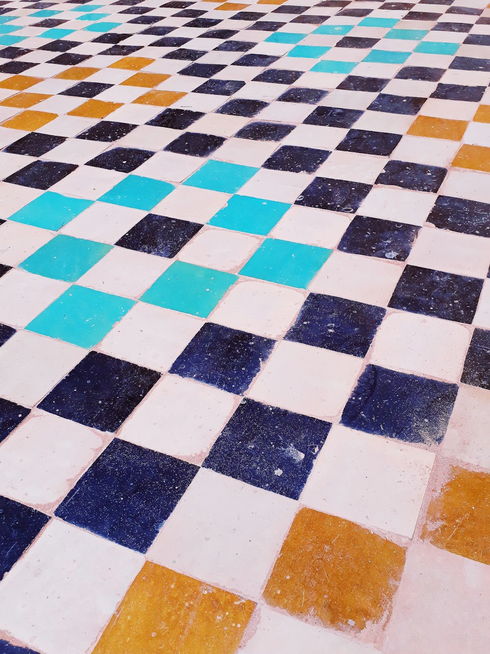 a tiled floor with blue, yellow and white tiles
