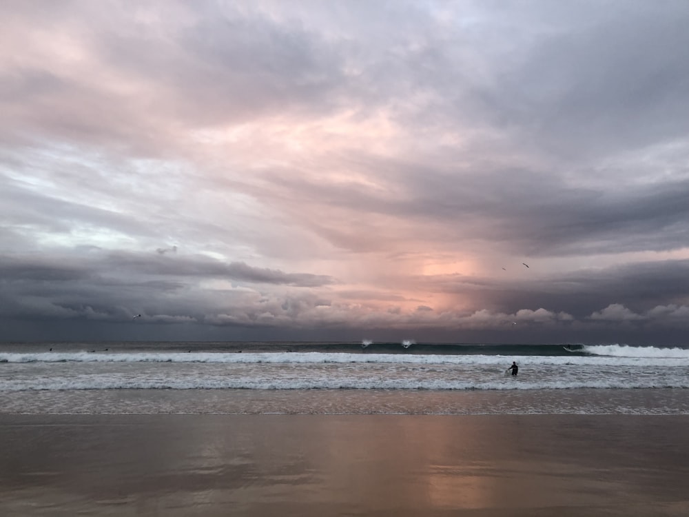 seashore under cloudy sky during daytime