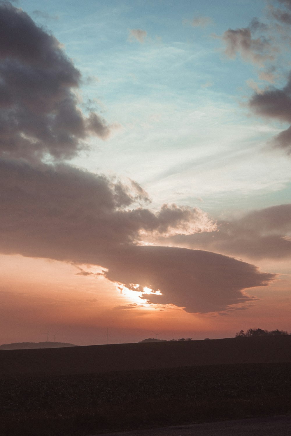 the sun is setting over the horizon of a field