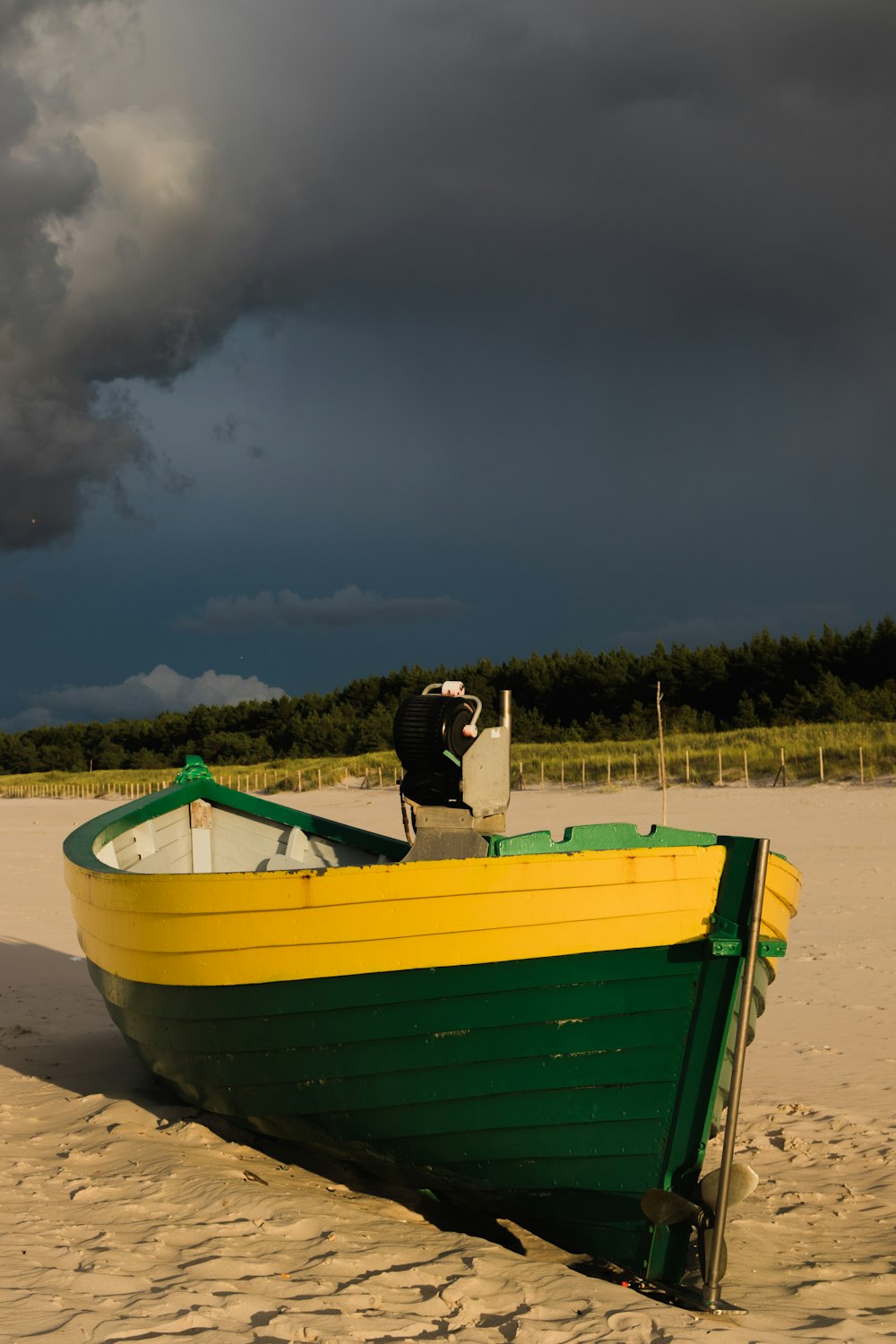 green and yellow canoe on gray sand during dawn